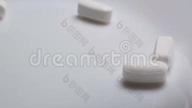 这种药物的<strong>白色</strong>胶囊正在从发光的<strong>白色</strong>桌子上的塑料瓶中<strong>掉落</strong>和粉碎。